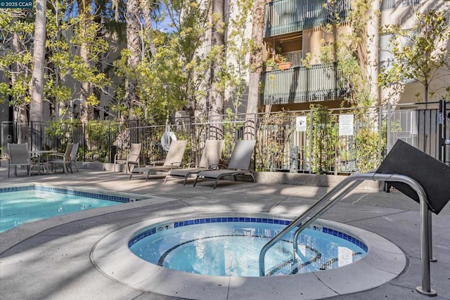 view of pool with a patio and a hot tub