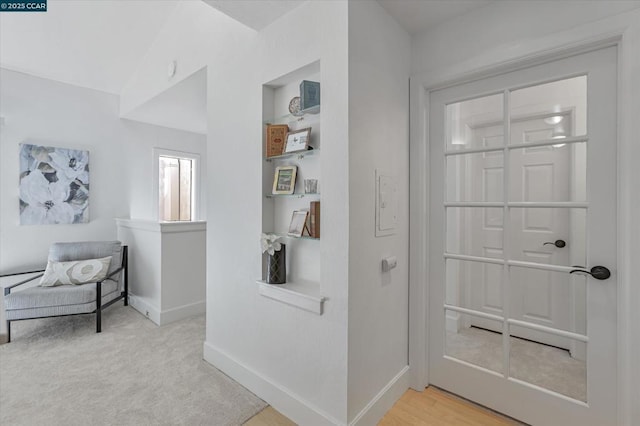 hallway featuring light colored carpet