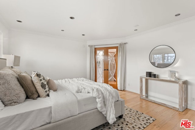 bedroom featuring crown molding, light wood-type flooring, and french doors