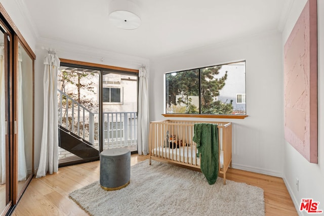 bedroom featuring multiple windows, crown molding, and hardwood / wood-style floors