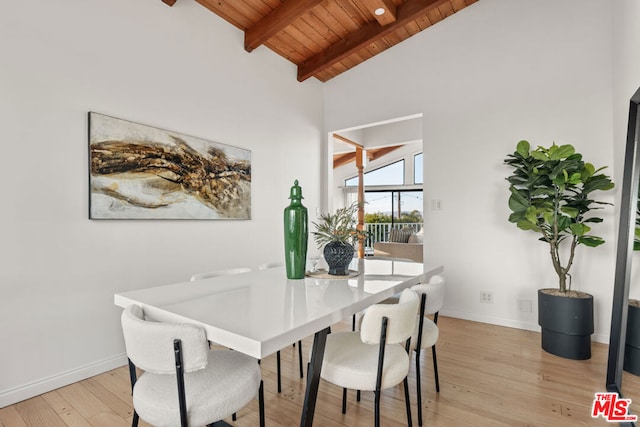 dining area with high vaulted ceiling, wood ceiling, beam ceiling, and light hardwood / wood-style flooring