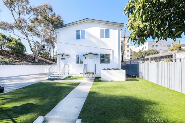 rear view of house featuring a yard