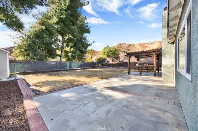 view of yard with a pergola, a mountain view, and a patio area