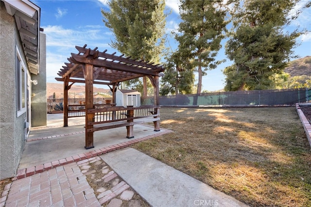 view of yard featuring a storage shed, a patio, a mountain view, and a pergola