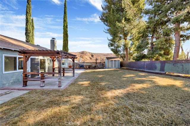 view of yard with a storage unit, a pergola, a patio area, and a mountain view