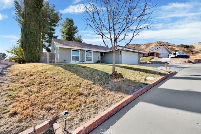 ranch-style house featuring a garage and a front yard