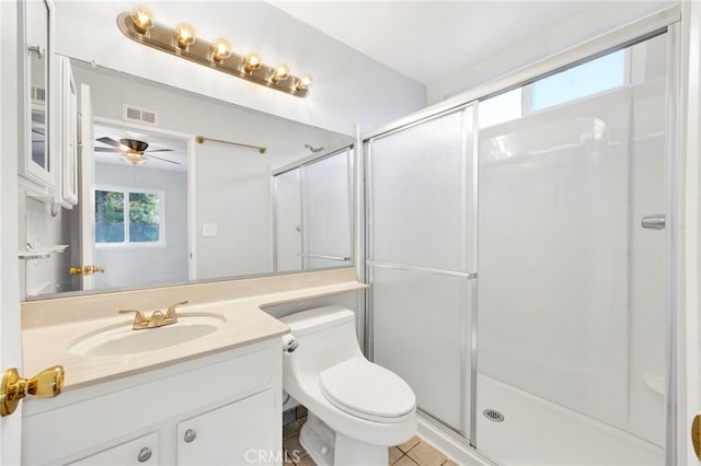 bathroom with tile patterned floors, toilet, a shower with door, and vanity