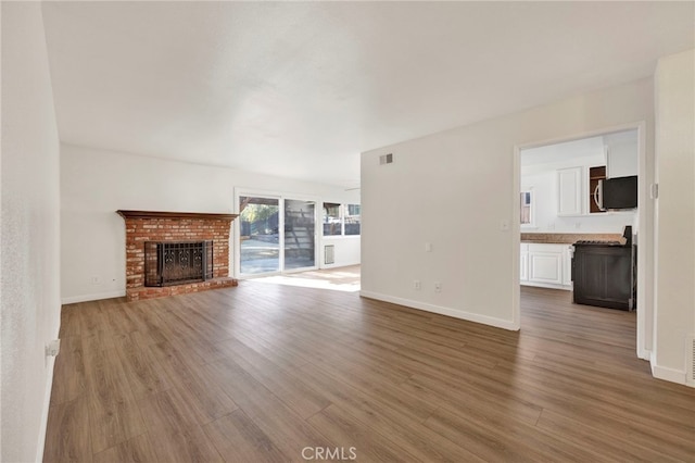 unfurnished living room with hardwood / wood-style flooring and a fireplace