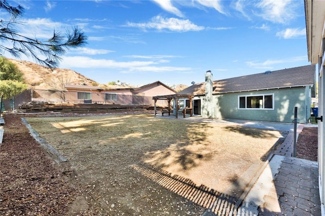 rear view of property featuring a pergola and a patio