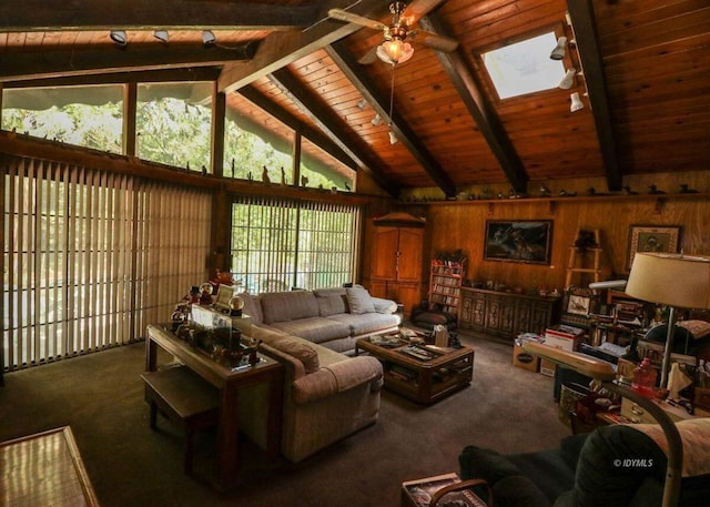 carpeted living room featuring wood walls, wooden ceiling, beam ceiling, and ceiling fan