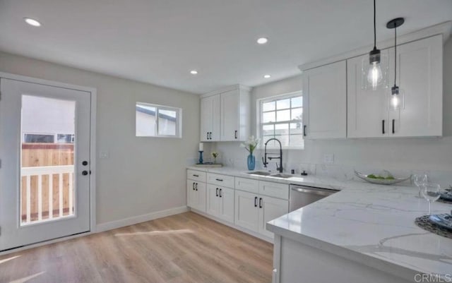 kitchen featuring dishwasher, white cabinetry, sink, decorative light fixtures, and light stone counters