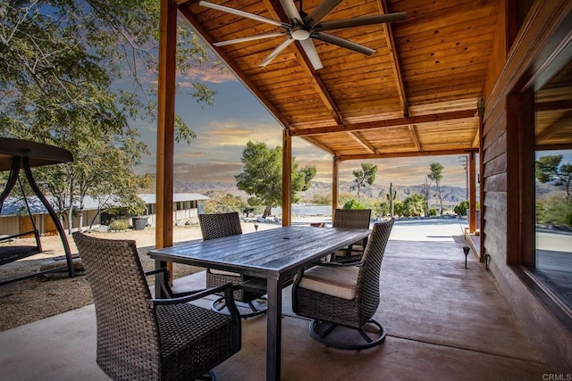 patio terrace at dusk featuring a mountain view and ceiling fan