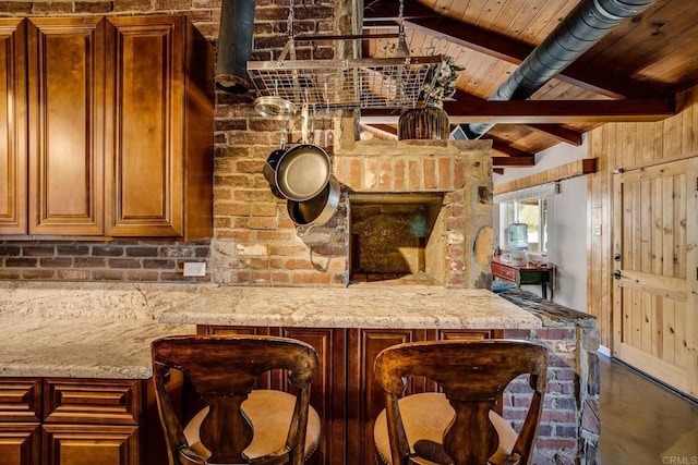 kitchen featuring wooden ceiling, vaulted ceiling with beams, and light stone counters