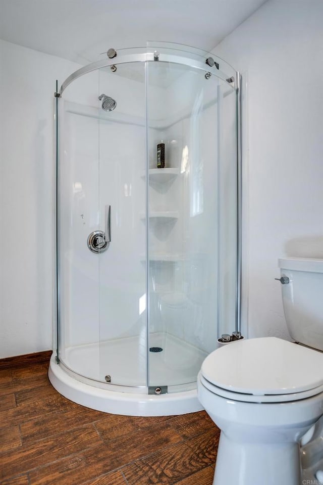 bathroom with wood-type flooring, toilet, and an enclosed shower