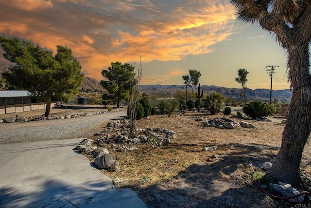 yard at dusk featuring a mountain view