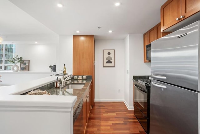 kitchen with hardwood / wood-style flooring, sink, black appliances, and kitchen peninsula