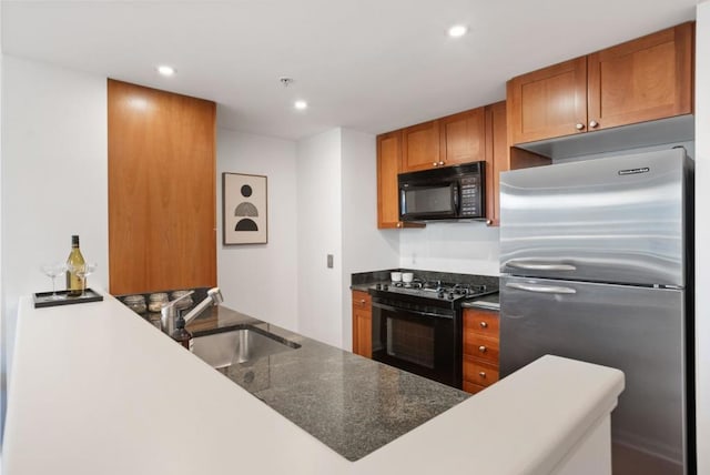 kitchen featuring black appliances, kitchen peninsula, and sink