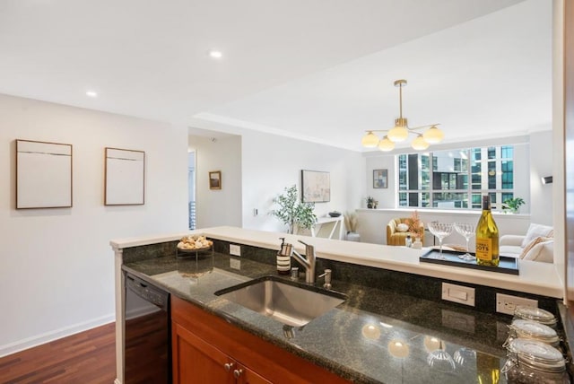 kitchen featuring dishwasher, sink, decorative light fixtures, dark hardwood / wood-style floors, and dark stone countertops