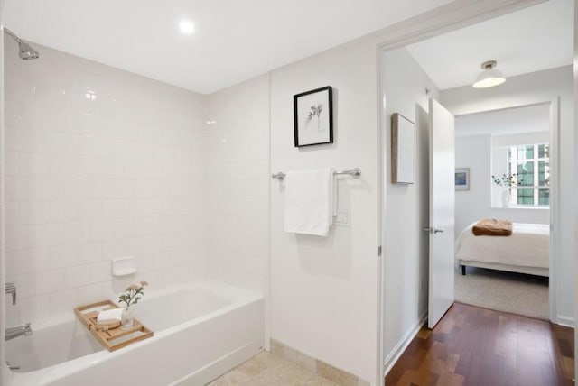 bathroom with hardwood / wood-style flooring and shower / tub combination