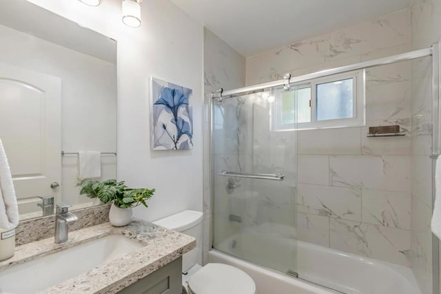 full bathroom featuring toilet, vanity, and shower / bath combination with glass door