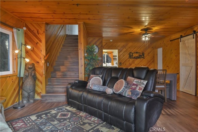 living room featuring dark wood-type flooring, wood ceiling, ceiling fan, and a barn door