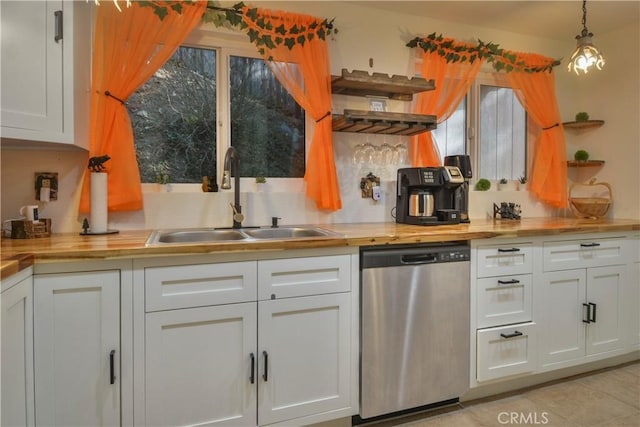 kitchen with decorative light fixtures, stainless steel dishwasher, and white cabinets