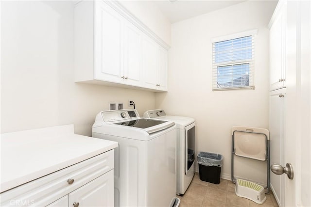 washroom with cabinets, light tile patterned floors, and washer and clothes dryer