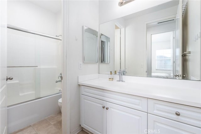 full bathroom featuring vanity, toilet, tile patterned flooring, and combined bath / shower with glass door