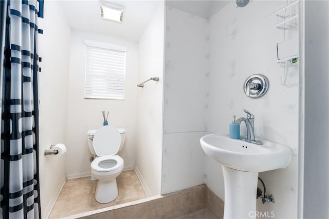 bathroom featuring tile patterned flooring, curtained shower, and toilet