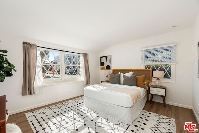 bedroom with hardwood / wood-style flooring and vaulted ceiling