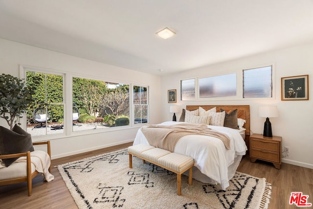 bedroom with light wood-type flooring and multiple windows