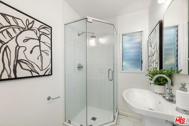 bathroom featuring sink, tile patterned floors, and a shower with door