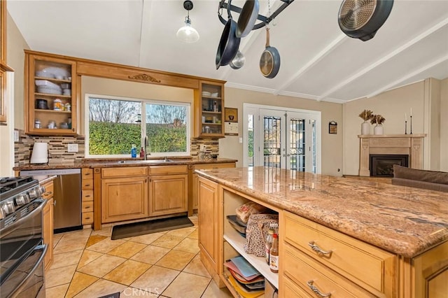 kitchen with sink, light stone counters, appliances with stainless steel finishes, and decorative backsplash