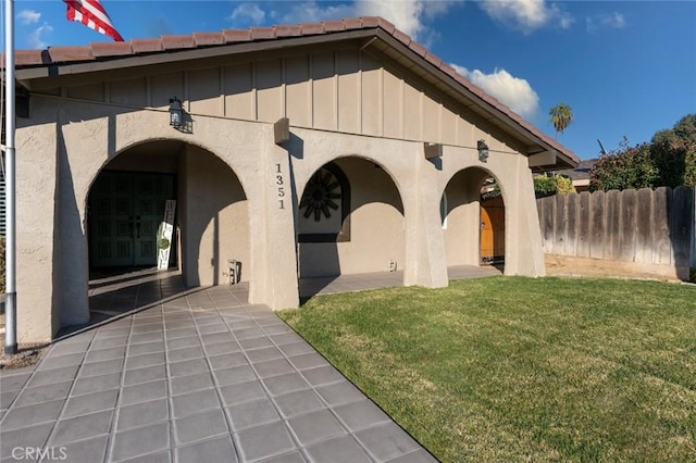 back of house with a lawn and a patio