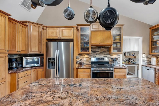 kitchen with decorative backsplash, decorative light fixtures, stainless steel appliances, and vaulted ceiling