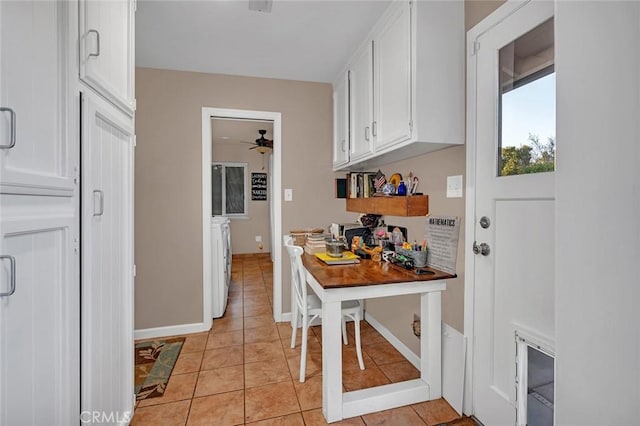 kitchen featuring washer and clothes dryer, light tile patterned floors, white cabinets, and ceiling fan