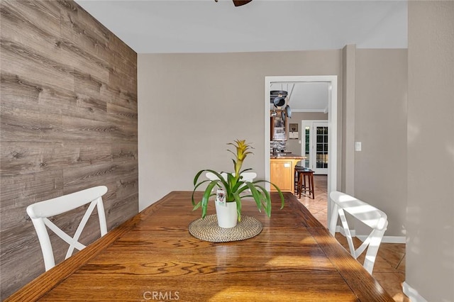 dining room featuring wood walls and ceiling fan