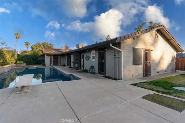 view of pool featuring a diving board and a patio