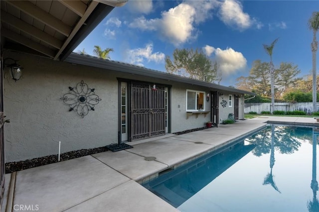 view of pool with a water view and a patio