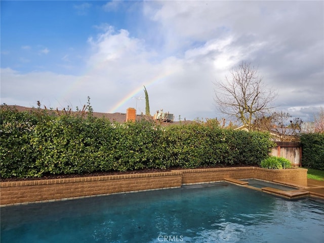 view of swimming pool featuring an in ground hot tub