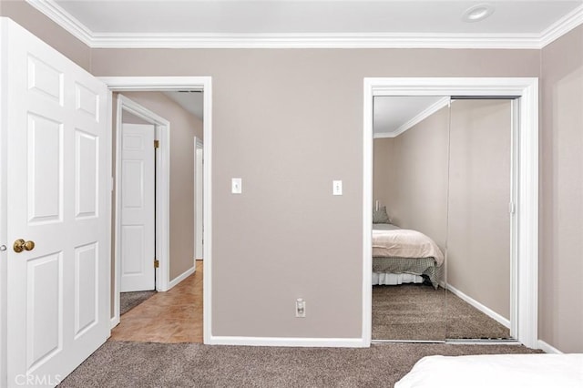 unfurnished bedroom with carpet, a closet, and ornamental molding