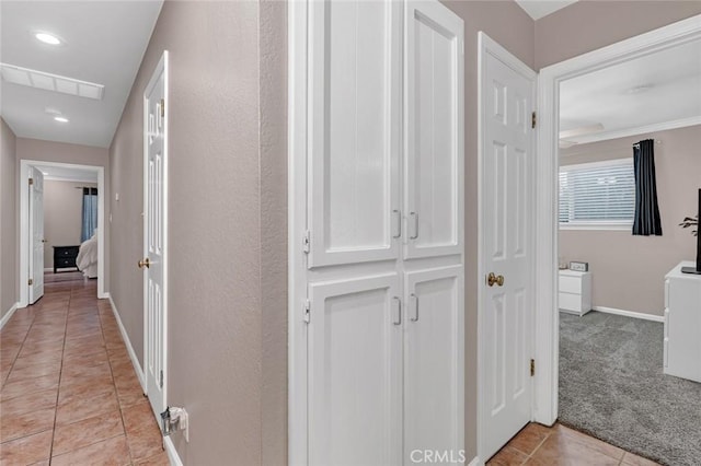 corridor with light carpet and crown molding