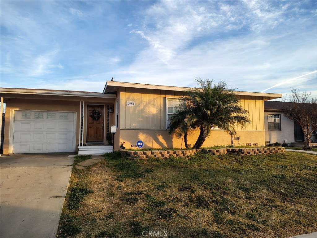 view of front of property with a garage and a front lawn