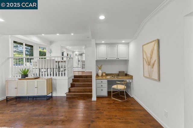 office area featuring built in desk, ornamental molding, and dark hardwood / wood-style floors