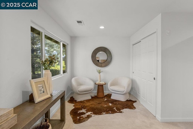 living area featuring light carpet