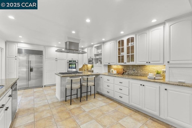 kitchen with light stone counters, backsplash, white cabinetry, and appliances with stainless steel finishes