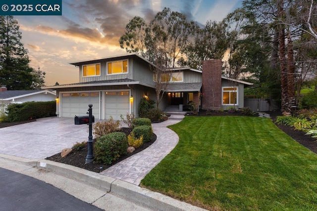 view of front of property with a garage and a lawn