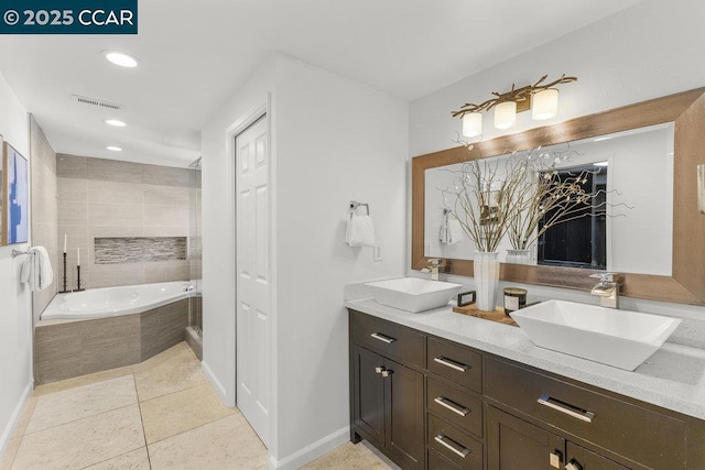 bathroom featuring tile patterned floors, vanity, and tiled bath