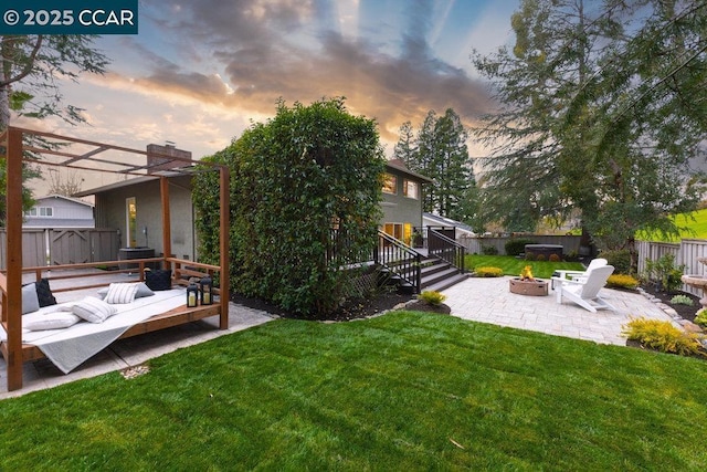 yard at dusk with a patio area and a fire pit