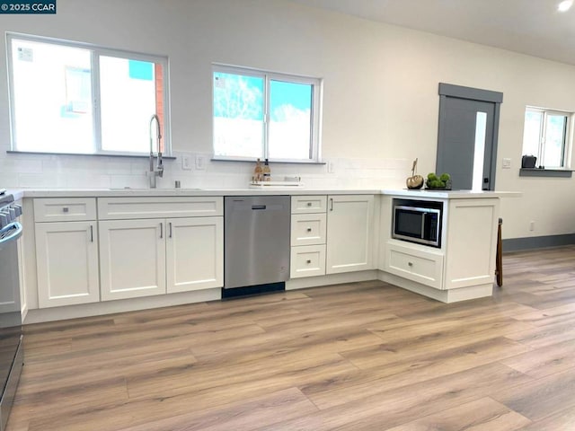 kitchen with white cabinetry, sink, light wood-type flooring, and appliances with stainless steel finishes